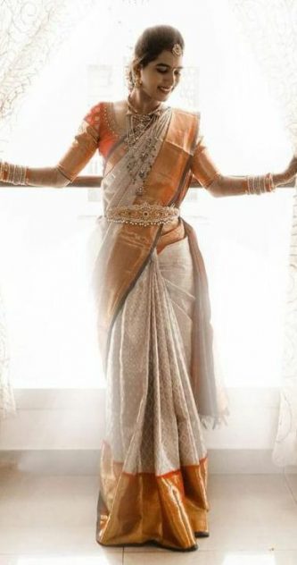 South Indian bride in cream pattu saree with orange border