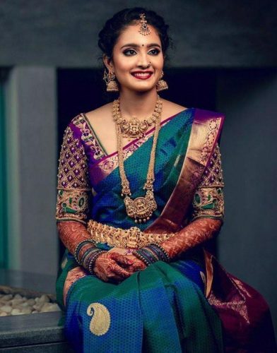 South Indian bride in peacock shade saree