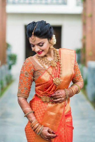 South Indian bride in orange silk saree