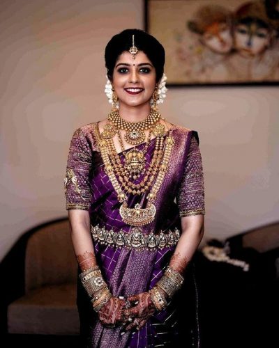 South Indian bride in purple saree with temple jewelry