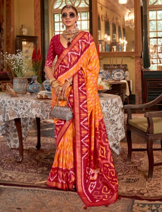Bright orange silk saree featuring maroon contrast pallu
