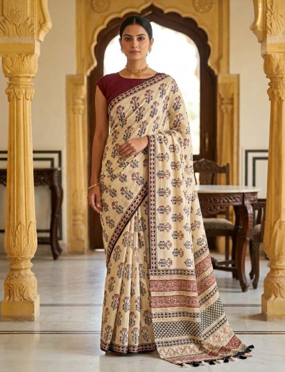 Beige muslin saree adorned with traditional prints