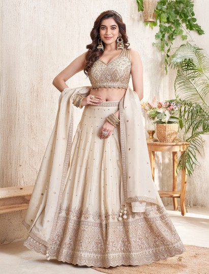 Cream silk lehenga choli with zardosi and tassel accents